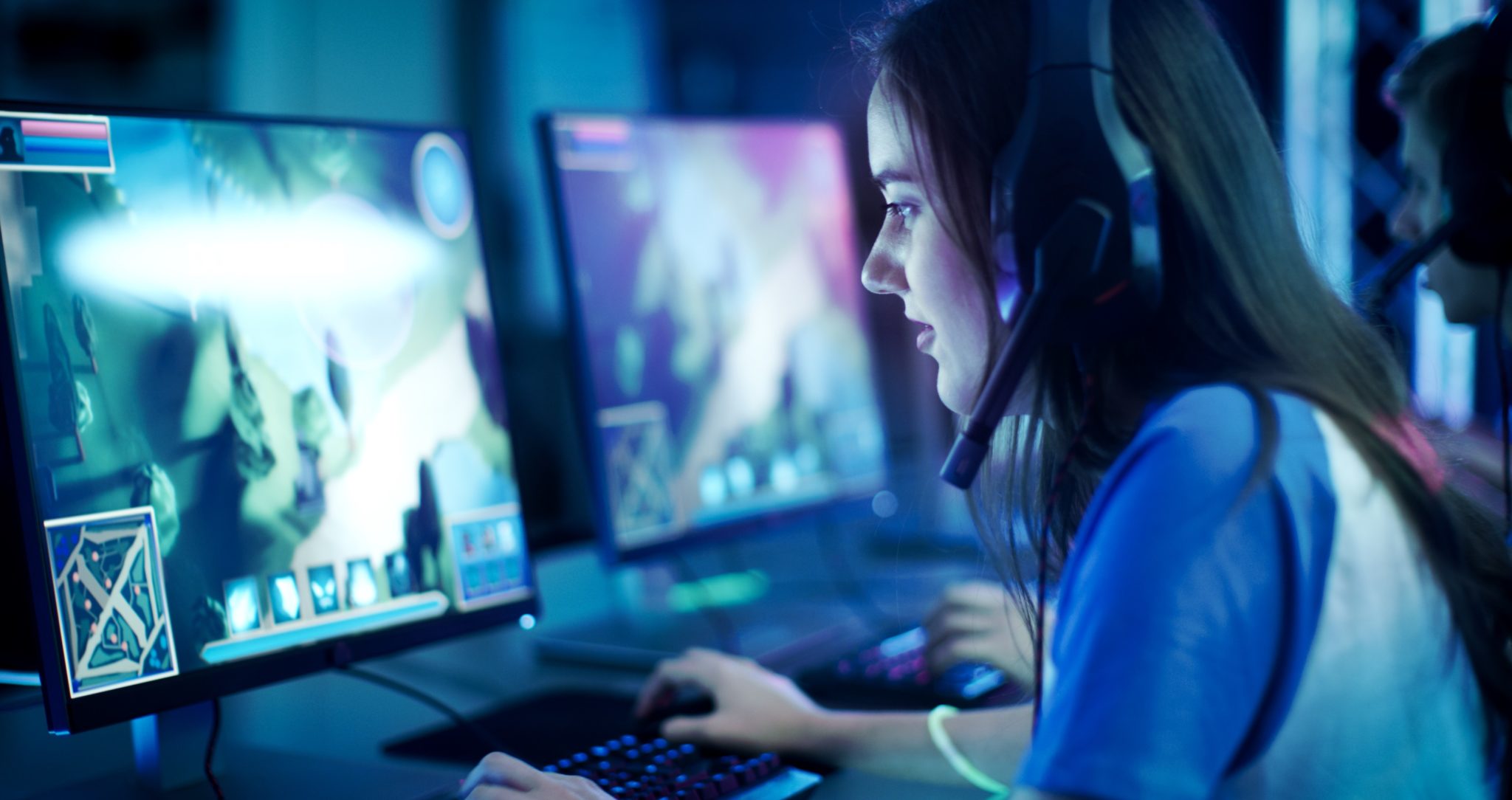 Professional Girl Gamer Plays in MMORPG/ Strategy Video Game on Her Computer. She's Participating in Online Cyber Games Tournament, Plays at Home, or in Internet Cafe. She Wears Gaming Headset. for SEO