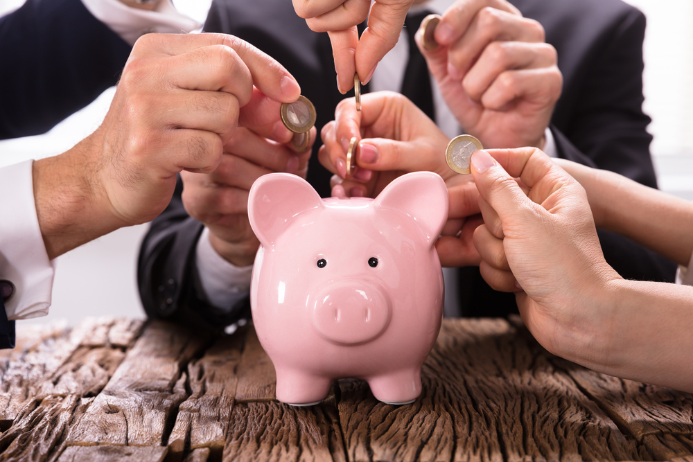 People Inserting Coins Into Piggybank for SEO