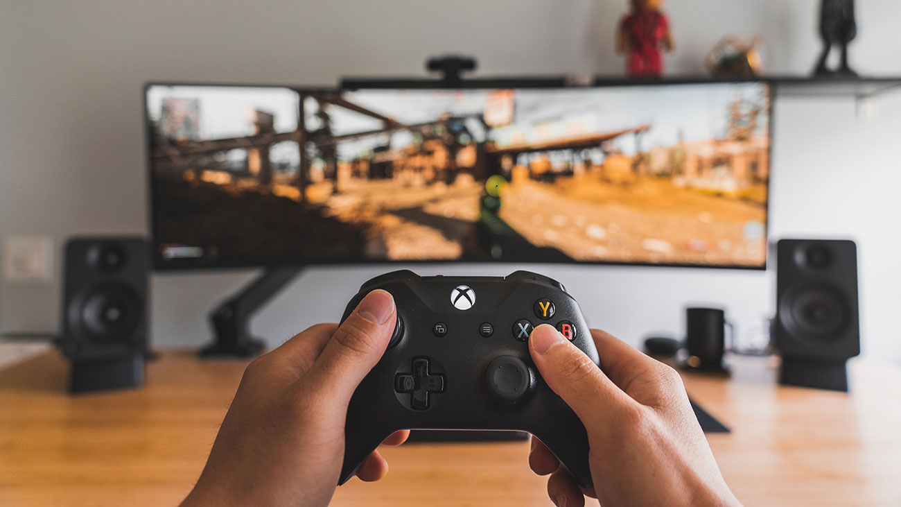 Ilustrasi bermain game PC menggunakan gamepad / Unsplash for SEO